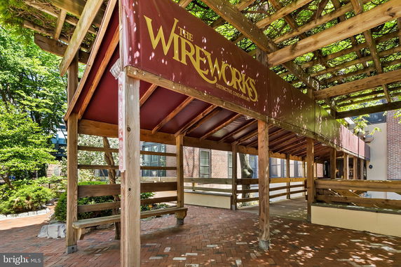 Front view of a building entrance with a wooden pergola and canopy.