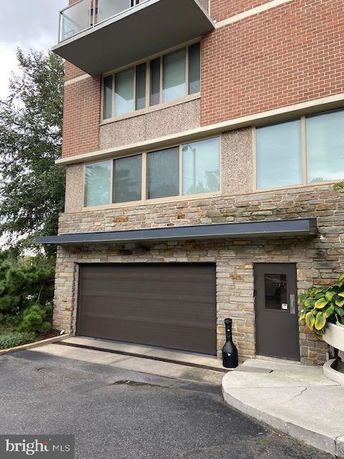 Front view of a multi-story building with a garage on the ground floor.