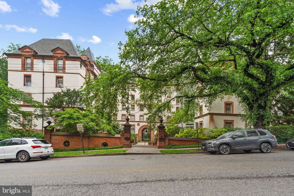 Front view of a multi-story building with a decorative brick facade and archway entrance.