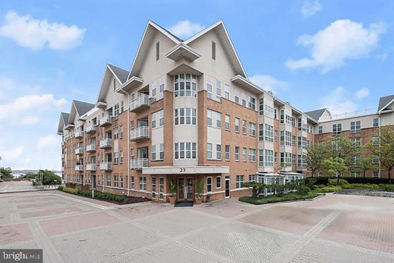 Front view of a multi-story brick apartment building with balconies.