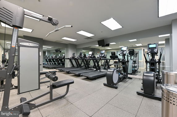 Interior view of a fitness room with various gym equipment including treadmills and exercise machines.