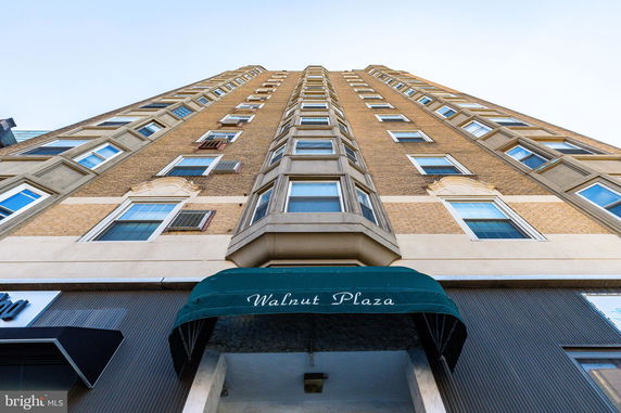 Front view of a tall multi-story building labeled Walnut Plaza.