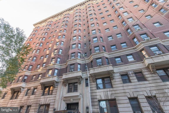 Front view of a multi-story brick building with numerous windows.