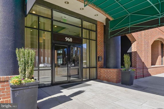 Front view of a building entrance with glass doors and brick facade.