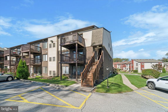 Front view of a multi-story apartment building with exterior stairs and balconies.