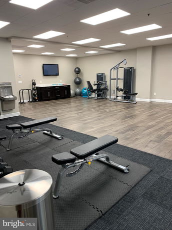 Indoor gym area with exercise equipment and weights.