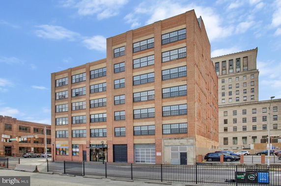 Front view of a multi-story brick building with numerous windows.