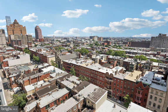 Panoramic view of cityscape showing buildings and skyline under a blue sky.