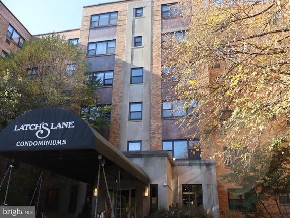 Front view of a multi-story condominium building with a covered entrance.