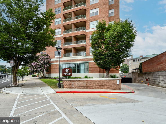 Front view of a multi-story brick building with balconies.