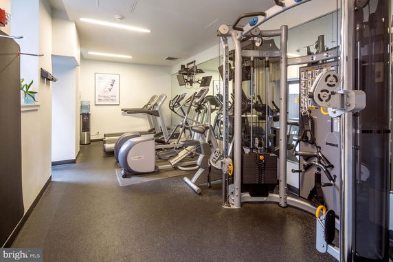 Indoor gym area with various fitness equipment including treadmills and weight machines.