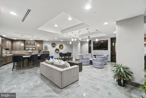Interior view of a clubhouse with seating and a kitchenette.