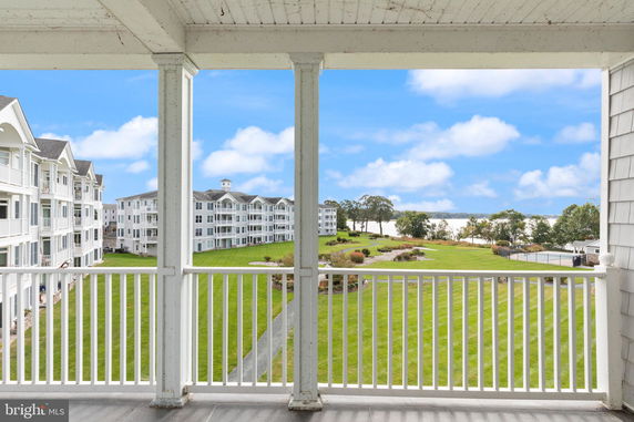 Panoramic view from a balcony overlooking apartment buildings and landscaped grounds.