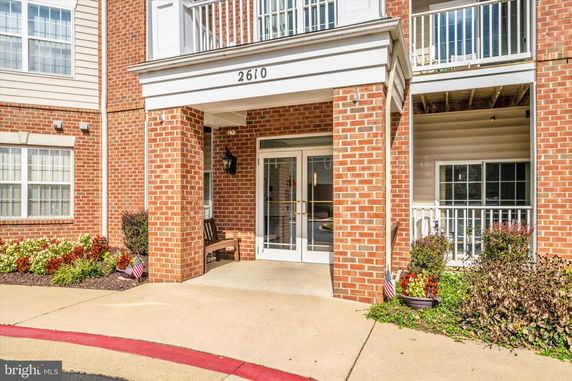 Front view of a building with a brick facade and glass entrance doors.
