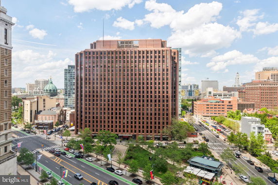 Front view of a tall brick office building in an urban setting.