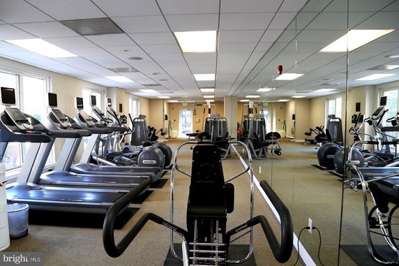Indoor gym area with treadmills, elliptical machines, and other fitness equipment.
