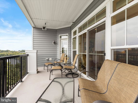 Balcony with seating overlooking a scenic view.
