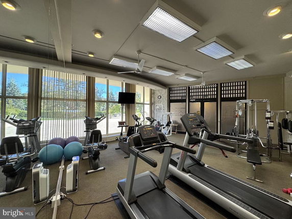 Interior view of a gym with exercise equipment, including treadmills and stationary bikes.