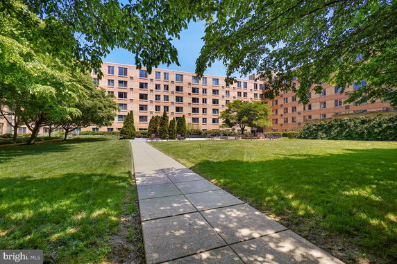 View of a multi-story apartment building with a landscaped courtyard.