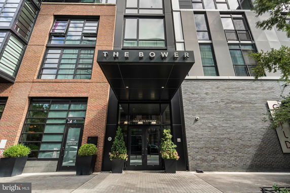 Front view of a modern multi-story building with brick and metal facade.