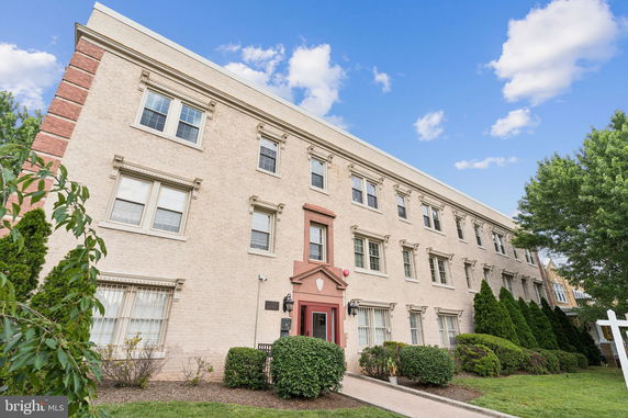 Front view of a three-story brick building with multiple windows and a central entrance.