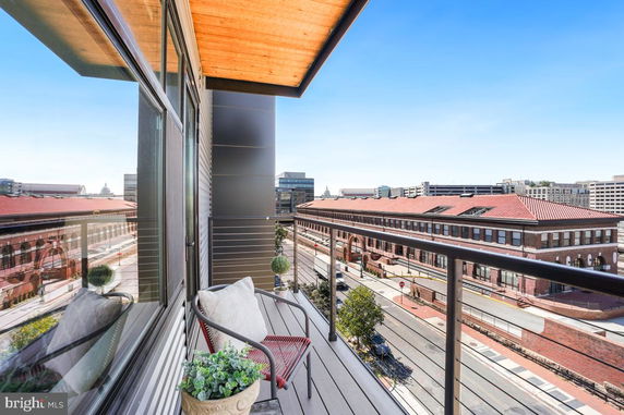 View from a balcony overlooking a street and surrounding buildings.