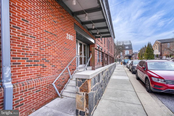 Front view of a brick building with metal railings and entrance steps.