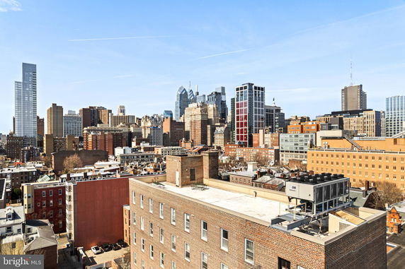 Panoramic view of a cityscape with tall buildings and a blue sky.