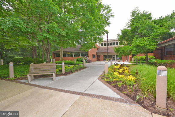 Front view of a building with a large entrance and surrounding greenery.