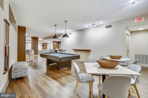 Interior view of a recreation room with billiard tables and seating areas.