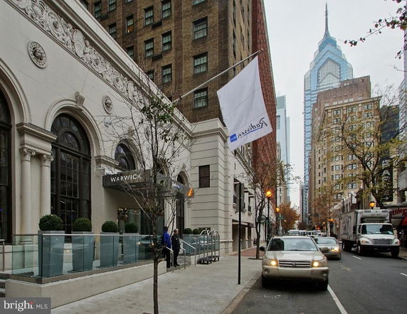 Front view of a multi-story building with an arched entrance and decorative facade.