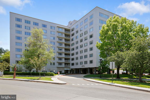 Front view of a multi-story residential building with balconies and large windows.