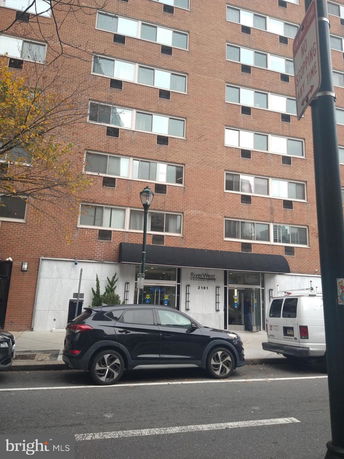 Front view of a multi-story building with large windows and a main entrance.