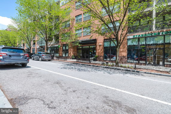 Front view of a brick building with ground-floor commercial spaces.