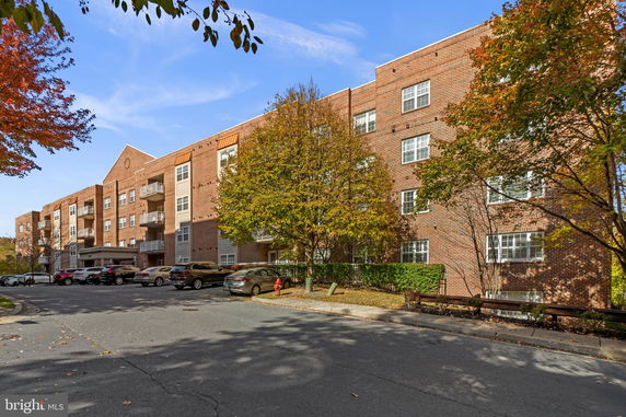 Front view of a multi-story apartment building with brick facade.