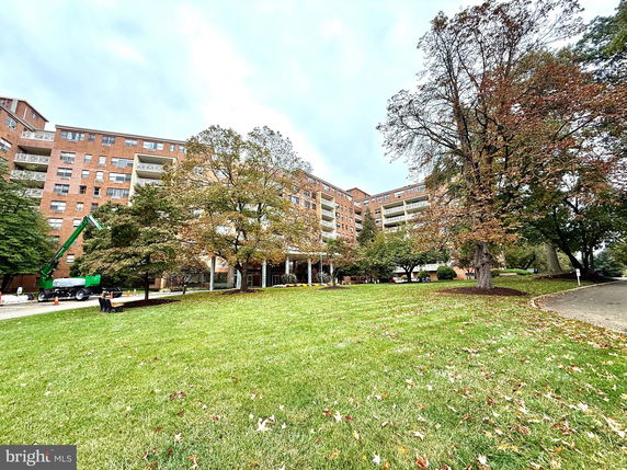 Front view of a multi-story brick apartment building with balconies.