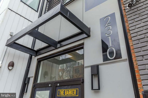 Front view of a modern building with large number '2310' and a door labeled 'The Barker.'