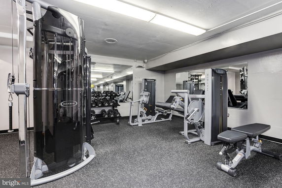 Gym area with various exercise machines and weights.