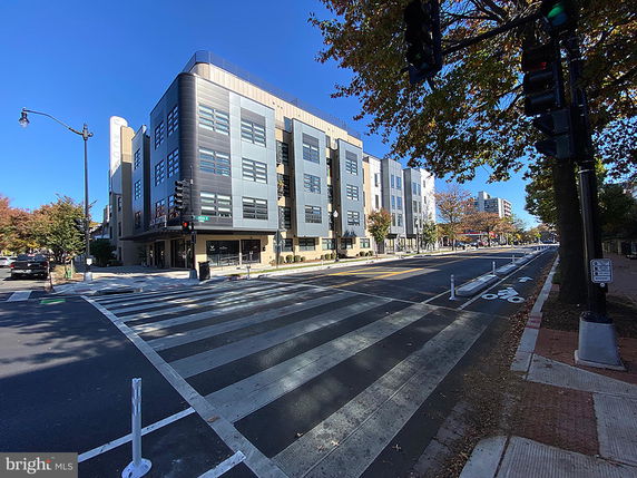 Front view of a multi-story commercial building on a city street corner.