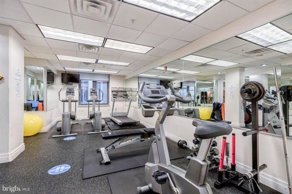 Indoor gym area with exercise equipment including treadmills and stationary bike.