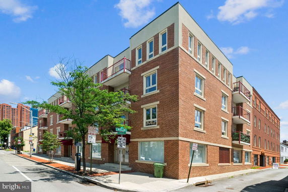 Front view of a multi-story brick building with balconies.