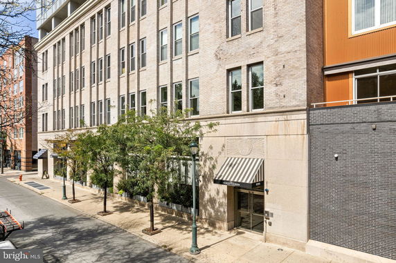 Front view of a multi-story building with brick facade and large windows.