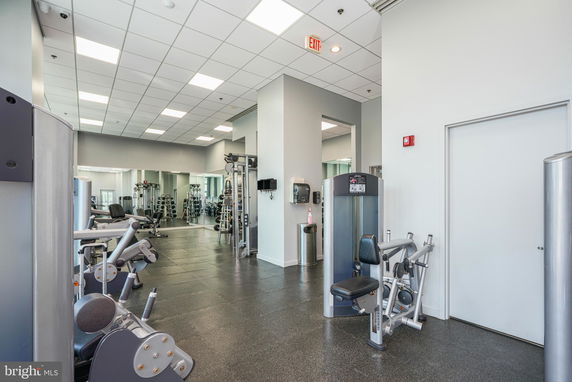 Interior view of a gym area with exercise equipment and mirror walls.