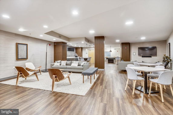 Spacious indoor club house with seating area, tables, and TV.