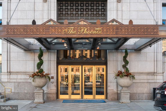 Front view of a building entrance with gold doors and a decorative canopy.