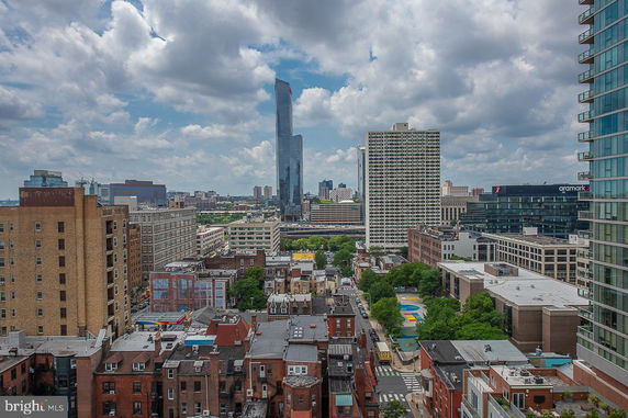Panoramic view of cityscape with tall buildings and cloudy sky.