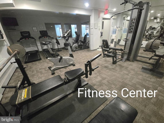 Interior of a fitness center with exercise equipment including cardio machines and weightlifting equipment.