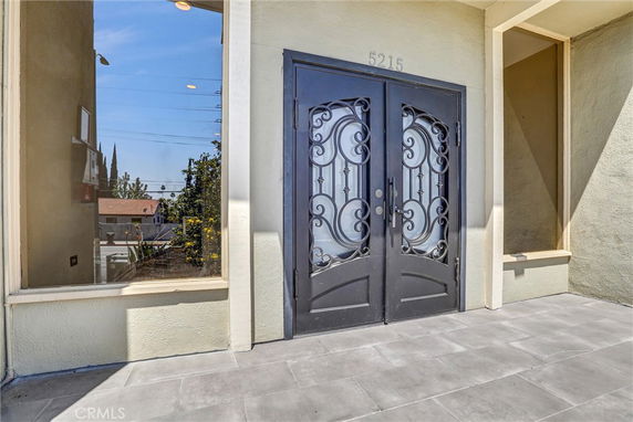 Front view of a house entrance with ornate double doors.