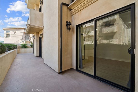 Exterior view of a building with sliding glass doors and balconies.