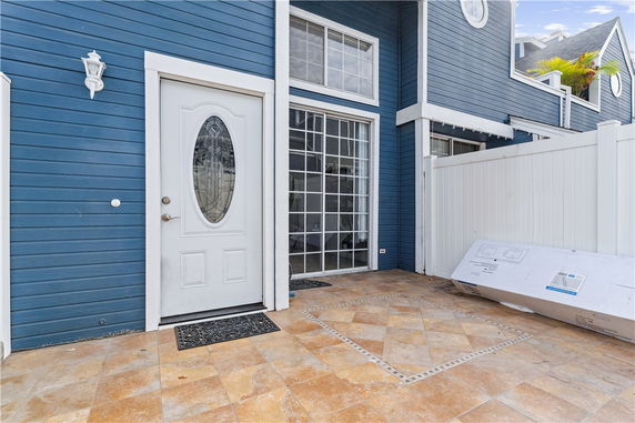 Front view of a blue two-story house with a white door and large windows.